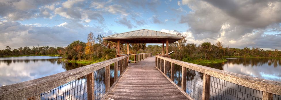 Gazebo on a wooden secluded, tranquil boardwalk along a marsh pond in Freedom Park in Naples, Florida