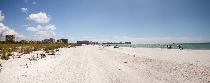 Blue sky over white sand and green beach grass of Tigertail Beach on Marco Island, Florida