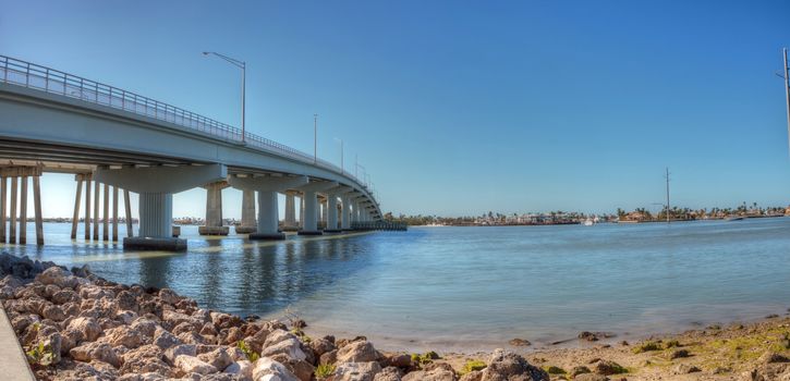 Blue sky over the bridge roadway that journeys onto Marco Island, Florida over the bay.