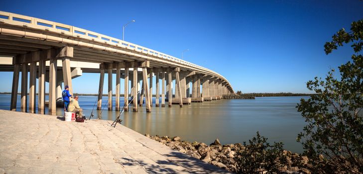 Blue sky over the bridge roadway that journeys onto Marco Island, Florida over the bay. 