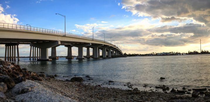 Blue sky over the bridge roadway that journeys onto Marco Island, Florida over the bay.