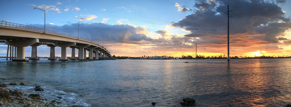 Sunset over the bridge roadway that journeys onto Marco Island, Florida over the bay.