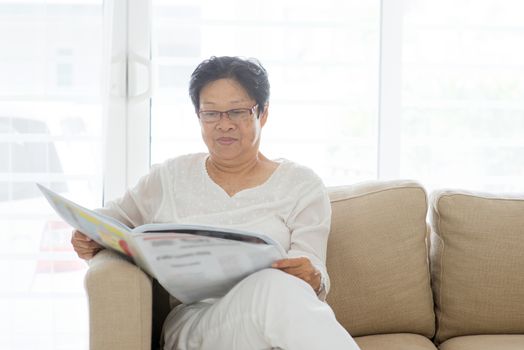 Asian elderly people reading newspaper at home, 60s old senior woman indoor lifestyle.