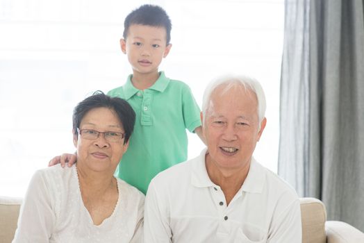 Portrait of Asian grandparents and grandchild at home, old senior retired people and child indoor lifestyle.