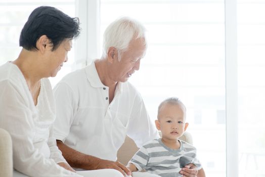 Portrait of Asian grandparents and grandchild at home, family indoor lifestyle.