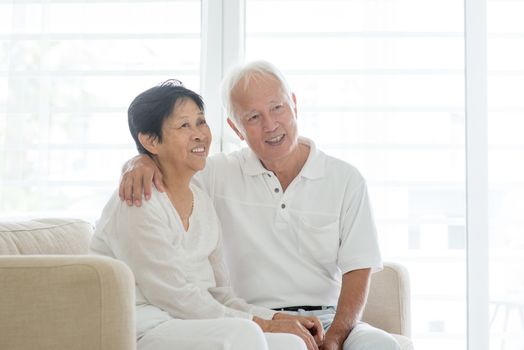 Portrait of happy Asian elderly couple at home, looking away, old senior retired people indoor lifestyle.