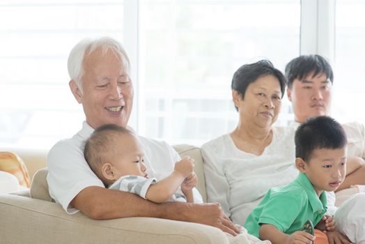 Candid of Asian family sitting at home, multi generations people indoor lifestyle.
