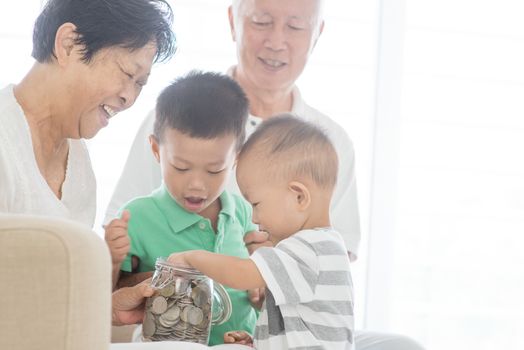 Asian family saving money at home. Financial planning, investment, insurance, retirement, senior and junior banking concept. 