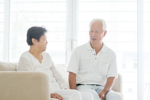 Portrait of serious Asian elderly couple talking at home, old senior retired people indoor lifestyle.