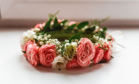 wreath of pink and white roses on the windowsill