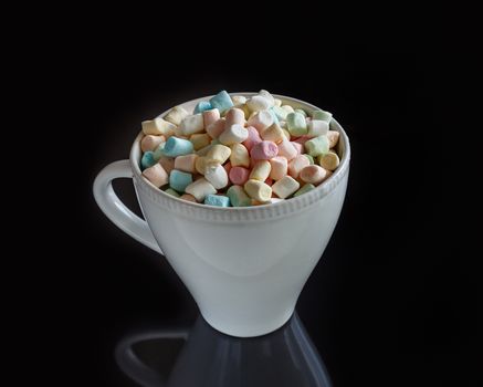 marshmallow in a white cup on a dark background