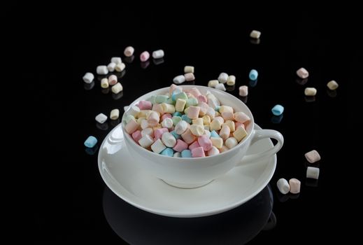 marshmallow in a white cup on a dark background