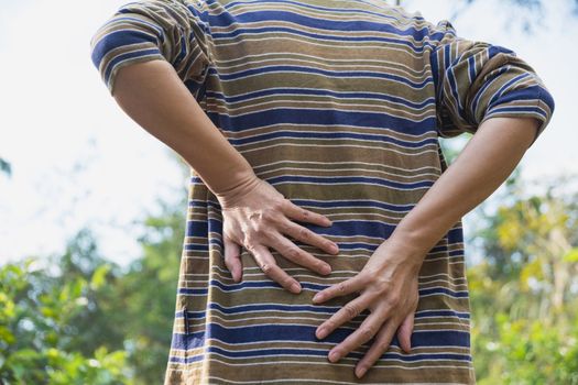 A man suffering from backache, spinal injury and muscle issue problem at outdoor.