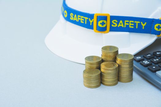 Safety engineer helmet with stack coins and calculator.