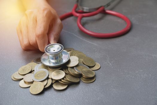 Stethoscope with Coins in jar with money stack, Concept finance, accounting, business and saving investment.