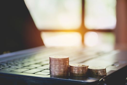 Stack coins on laptop. Financial, accounting and saving concept.