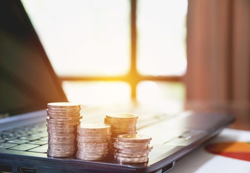 Stack coins on laptop. Financial, accounting and saving concept.
