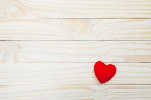 Red heart on wooden table with copy space for valentine day concept.