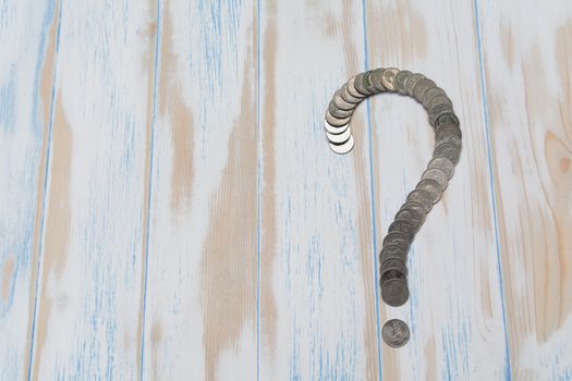 Saving money concept and money coin shape question mark  on wooden table for business.