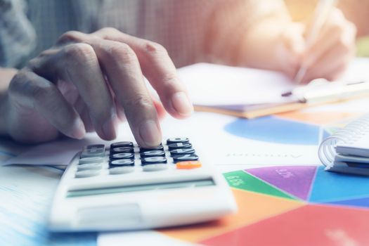 Man using calculator with stock financial indices with stack coin. Financial stock market in accounting market economy analysis.