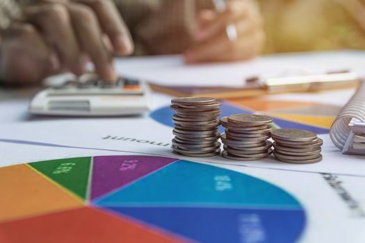 Man using calculator with stock financial indices with stack coin. Financial stock market in accounting market economy analysis.