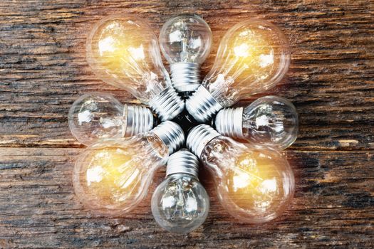 Light bulbs with glowing on wooden table background. Idea, creativity and saving energy with light bulbs concept.