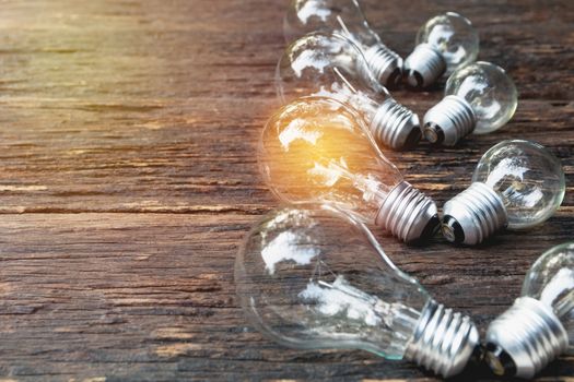 Light bulbs with glowing on wooden table background. Idea, creativity and saving energy with light bulbs concept.