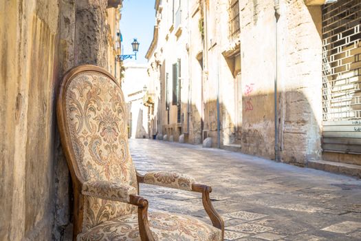 Lecce town, Italy. Vintage chair with old town street in background.