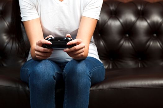 Closeup shot of manicured female hands with black gamepad