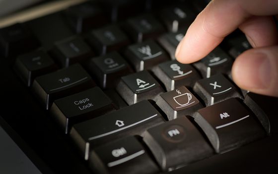 Coffee sign on computer keyboard and man finger