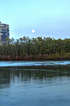 Moonrise over River leading to the ocean at Clam Pass at dusk in Naples, Florida