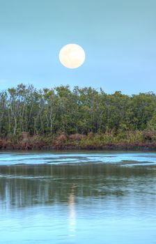 Moonrise over River leading to the ocean at Clam Pass at dusk in Naples, Florida