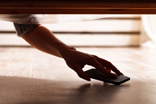 Someone is hiding a smartphone under the bed