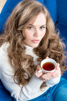 top view of a beautiful girl with a cup of tea on the couch