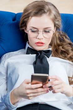 young successful businesswoman with glasses looking into smartphone