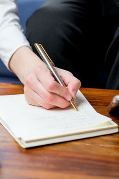 young girl is making notes in a notepad pen, close-up hand
