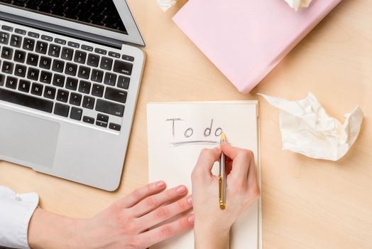 top view of the desktop, notepad for notes and female hands