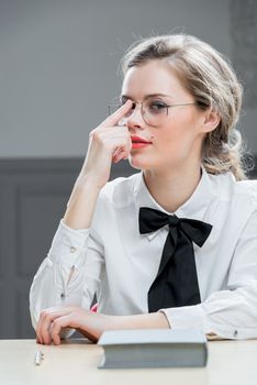 beautiful girl in stylish glasses sits at the table