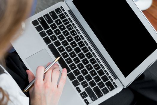 top view of laptop and female hands while working