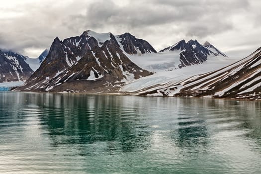 Cloudy sky over the mountains along the Magdalenafjord in Svalbard islands, Norway