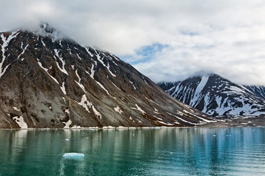 Cloudy sky and mountains along the Magdalenafjord in Svalbard islands, Norway