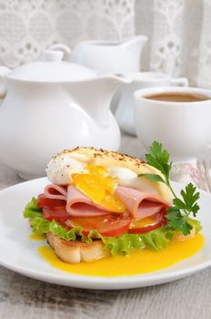 Toast with slices of ham and tomatoes, Benedict egg with Dutch sauce for Breakfast