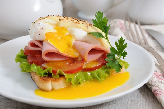 Toast with slices of ham and tomatoes, Benedict egg with Dutch sauce.