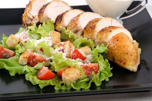 Sliced baked chicken breast with garnish  a la Caesar. 