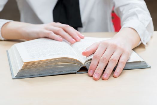 an interesting novel on a close-up table and women's hands