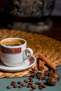 vertical picture of a beautiful cup of coffee, anise and cinnamon still life on a table