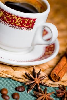 vertical still life delicious coffee in a beautiful cup with spices of cinnamon and anise