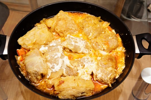 Freshly stuffed cabbage in tomato sauce with sour cream.
