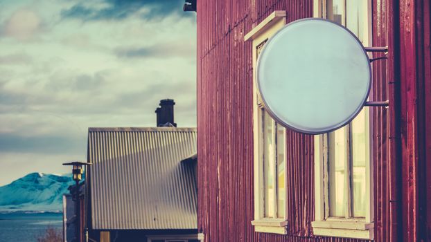 A Blank Sign Outside A Business In Reykjavik, Iceland, With Snowy Mountains In The Distance