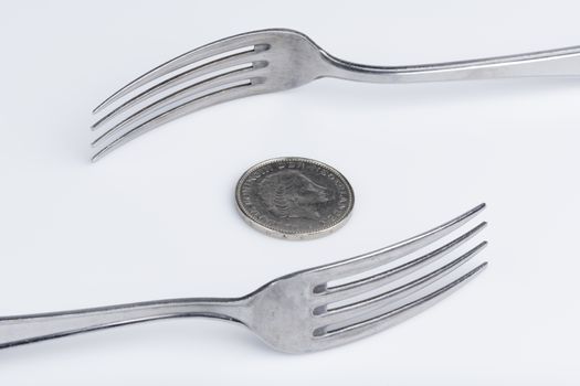 Conceptual representation of financial greed by two forks and coins
